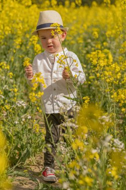 Köyde şık giyinmiş küçük bir çocuk var..