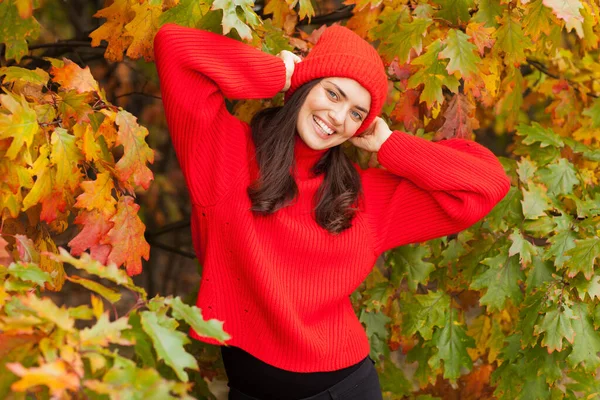 Güz manzaralı güzel esmer, kırmızı şapkalı ve atkılı..