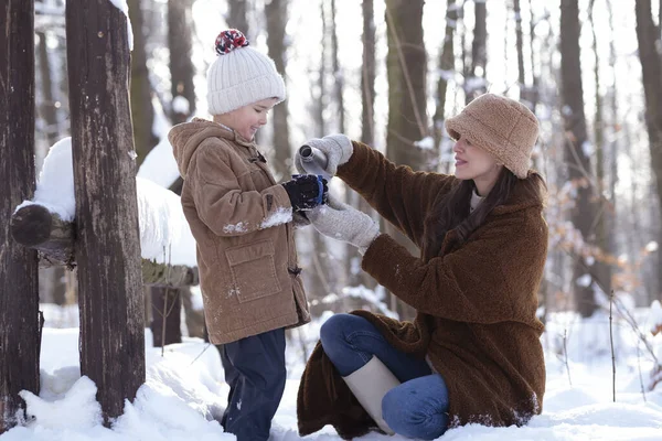 ママと息子は冬の散歩を楽しみ お茶を飲んでクリスマスツリーを飾る — ストック写真
