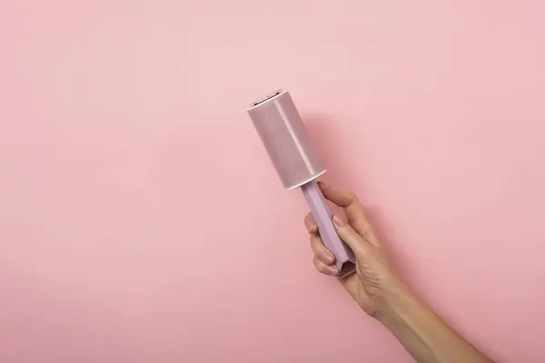 Stofroller Hand Van Een Vrouw Een Roze Achtergrond — Stockfoto