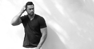 Siyah beyaz fotoğraf çekimindeki yakışıklı kaslı adam..