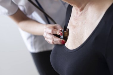 Genç bir doktor yaşlı bir hastayı muayene eder..