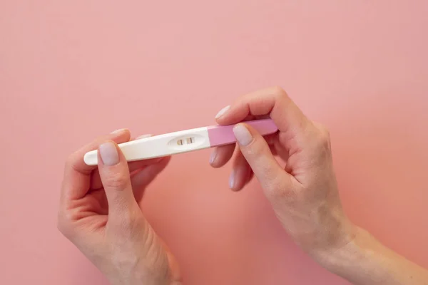 Prueba Embarazo Positiva Mano Una Mujer Sobre Fondo Rosa Pastel —  Fotos de Stock