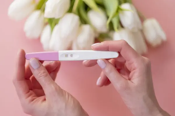 Prueba Embarazo Positiva Mano Una Mujer Sobre Fondo Rosa Pastel —  Fotos de Stock