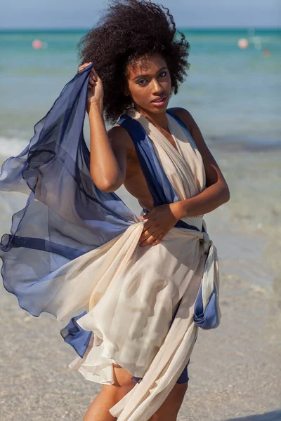 A beautiful black woman in a flowing dress.