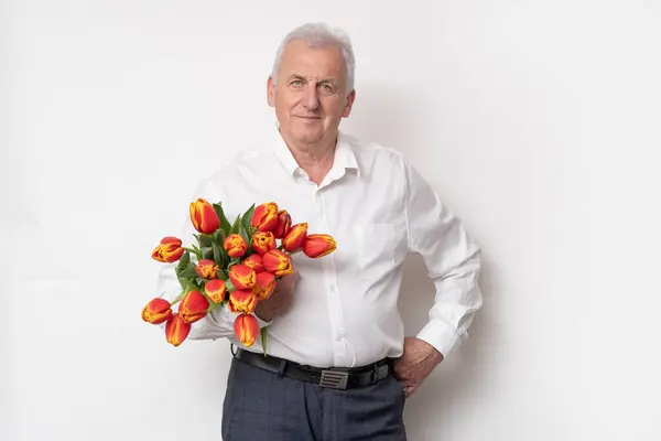 チューリップの花束を持つハンサムな老人 — ストック写真