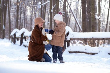 Anne ve oğlu kış yürüyüşü yaparken, çay içerken ve Noel ağacını süslerken çok eğleniyorlar..