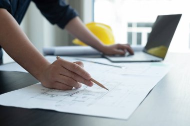 İnşaatta çalışan mimarlar ya da mühendisler inşaat planları, baskı, inşaat sahalarında yazılar çiziyor. Ev tasarımı kavramı.