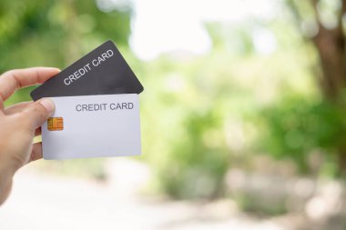 Credit Card. hand holding credit card with green nature background and copy space concept online shopping and Payments.