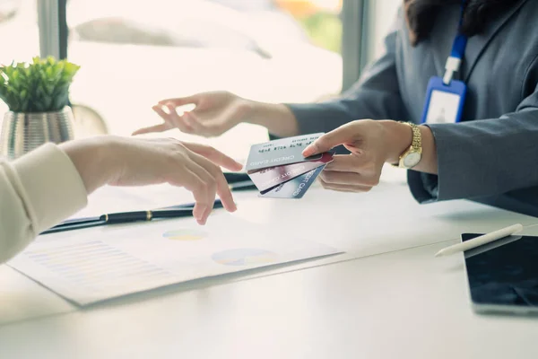 stock image Asian business customer service representatives work serve sell credit card to customers. choosing insurance plan in office.