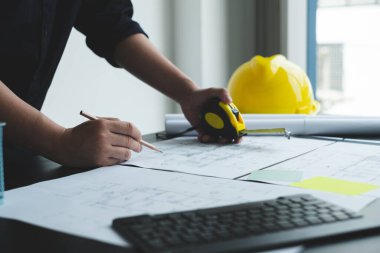 İnşaatta çalışan mimarlar ya da mühendisler inşaat planları, baskı, inşaat sahalarında yazılar çiziyor. Ev tasarımı kavramı.