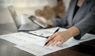 Yatırımlarının sonuçlarını gösteren grafikler üzerinde finansal yatırım, hesaplama, analiz ve pazarlama üzerinde çalışan iş kadınları veya muhasebeciler başarılı bir iş büyüme süreci planlamaktadırlar..