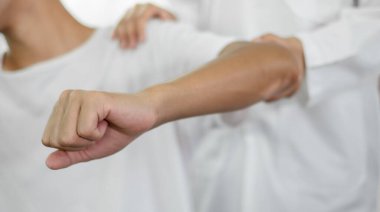 Kadın fizyoterapistler erkek hastalara dirsek yaralanmalarında ve rehabilitasyon merkezlerindeki hastaları muayene etmede yardımcı oluyorlar. Fizyoterapi kavramları.