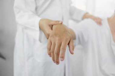 Omzundan yaralanan hastalar rehabilitasyon merkezinde kas tedavisi için omuzlarına masaj yapıyorlar. Fizyoterapi kavramları.