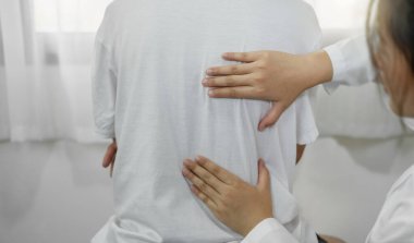 Kadın fizyoterapistler, erkek hastalara sırt yaralanmaları ve rehabilitasyon merkezinde rahatlama ve kas iyileşmesi için masaj yapıyorlar..