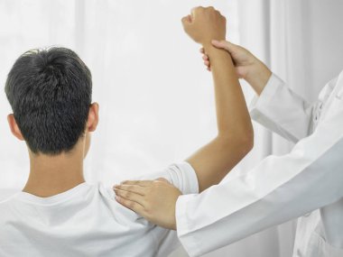 Omzundan yaralanan hastalar rehabilitasyon merkezinde kas tedavisi için omuzlarına masaj yapıyorlar. Fizyoterapi kavramları.