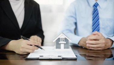 Ev modeli olan bir emlakçı müşterilerle ev kiralamak, ev sigortası yaptırmak ve resmi pazarlıklar tamamlandıktan sonra sözleşmeyi imzalamak hakkında konuşuyor..