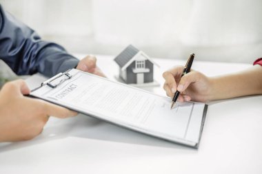 Ev modeli olan bir emlakçı müşterilerle ev kiralamak, ev sigortası yaptırmak ve resmi pazarlıklar tamamlandıktan sonra sözleşmeyi imzalamak hakkında konuşuyor..