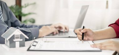 Ev modeli olan bir emlakçı müşterilerle ev kiralamak, ev sigortası yaptırmak ve resmi pazarlıklar tamamlandıktan sonra sözleşmeyi imzalamak hakkında konuşuyor..