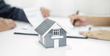 Ev modeli olan bir emlakçı müşterilerle ev kiralamak, ev sigortası yaptırmak ve resmi pazarlıklar tamamlandıktan sonra sözleşmeyi imzalamak hakkında konuşuyor..