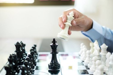 Satranç oynayan iş adamlarının eli liderlik, takipçiler ve ticari başarı stratejilerini gösteriyor.