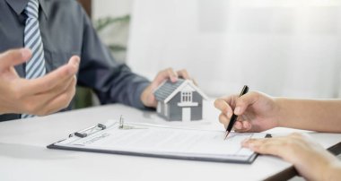 Ev modeli olan bir emlakçı müşterilerle ev kiralamak, ev sigortası yaptırmak ve resmi pazarlıklar tamamlandıktan sonra sözleşmeyi imzalamak hakkında konuşuyor..