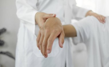 Kadın fizyoterapistler, erkek hastalara omuz sakatlığı olan hastalar için rehabilitasyon merkezinde omuzlarına masaj yapıyorlar. Fizyoterapi kavramları.