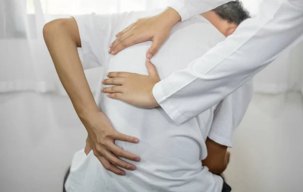 在康复中心 女物理治疗师为背部受伤的男性患者提供身体帮助 以放松身心和恢复肌肉 — 图库照片