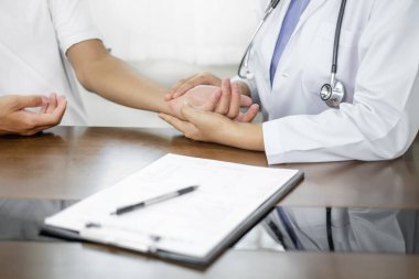 Kadın doktor kan basıncını ölçtü, hasta kalp atışlarını inceledi ve sağlık hizmetleri hakkında konuşmak için oturdu. sağlık hizmeti kavramı.