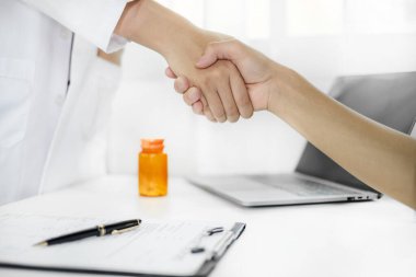 Doktor ve hasta tedaviden sonra hastanede el sıkışıyor. sağlık hizmeti kavramı.