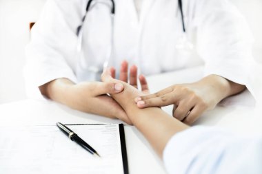 Kadın doktor kan basıncını ölçtü, hasta kalp atışlarını inceledi ve sağlık hizmetleri hakkında konuşmak için oturdu. sağlık hizmeti kavramı.