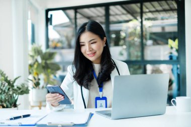 Asyalı iş kadını yatırımları hakkında sonuçlar gösteren mali grafikler hesaplıyor, başarılı iş büyüme süreci planlıyorlar.