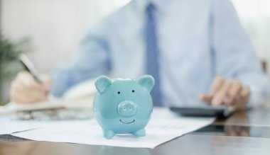 Piggy Bank 'a para yatıran bir adam, onun harcamalarını bir defter üzerinden hesaplıyor. Para biriktiriyorum. Başarılı olmak için büyüyen ve emeklilik kavramları için biriktirilen bir işe adım atıyorum..