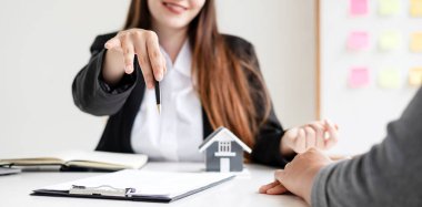 House Modeli 'ndeki emlakçı müşterilerle ev sigortası hakkında konuşuyor. Ev sigortası kavramı.