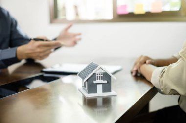 House Modeli 'ndeki emlakçı müşterilerle ev sigortası hakkında konuşuyor. Ev sigortası kavramı.