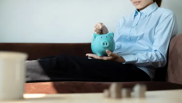 A young woman teaches how to put coins in a piggy bank start a growing business for success and save for retirement concept.
