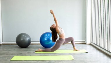 Profesyonel genç bayan yoga öğretmeni yoga esneme, fitness için egzersiz, fiziksel ve zihinsel sağlık konsepti öğretiyor..