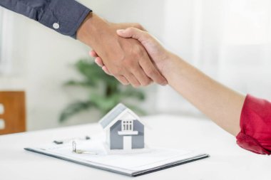 İş adamları ve emlakçılar, ev sigortası ve sözleşme imzalama görüşmelerini tamamladıktan sonra el sıkışıyorlar. ev sigortası kavramı.