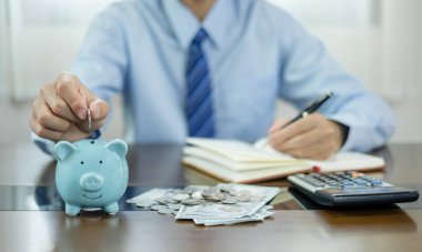 Piggy Bank 'a para yatıran bir adam, onun harcamalarını bir defter üzerinden hesaplıyor. Para biriktiriyorum. Başarılı olmak için büyüyen ve emeklilik kavramları için biriktirilen bir işe adım atıyorum..
