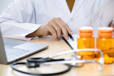 Kadın doktor oturdu ve hastanın geçmişini kontrol etti ve hasta bilgilerini kaydetmek için bir dizüstü bilgisayar kullandı. Tıbbi kavramlar ve ilgi alanları.