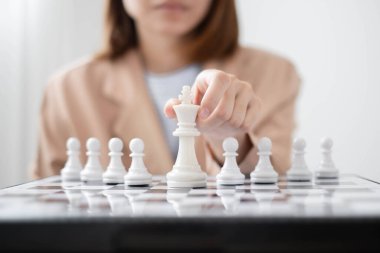 Satranç oynayan iş kadını eli liderlik, takipçiler ve iş dünyasının başarı stratejilerini gösteriyor.