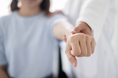 Kadın fizyoterapistler, omuz yaralanması olan hastalara rehabilitasyon merkezinde kas tedavisi için omuzlarına masaj yapıyorlar. Fizyoterapi kavramları.