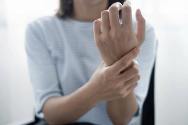 Bileğinde ağrı, avucunda uyuşukluk ve ağrı olan bir kadın elinin sinir uçlarında ağrı ve karıncalanma vardır. Bu ofiste uzun süre oturup çalışmanın bir yan etkisidir..