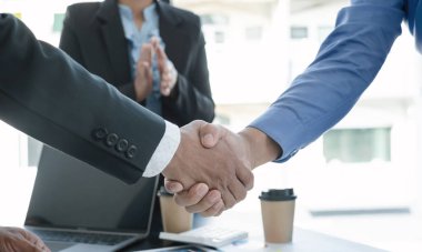 İş adamları toplantı başarıyla sonuçlandıktan sonra el sıkıştılar ve anlaştılar..