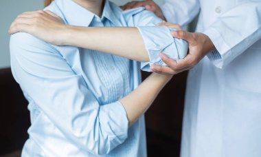 Kadın fizyoterapistler, dirsek yaralanması olan kadın hastalara rehabilitasyon merkezlerindeki hastaları muayene etmeleri için fiziksel yardım sağlıyorlar. Fizyoterapi kavramları.