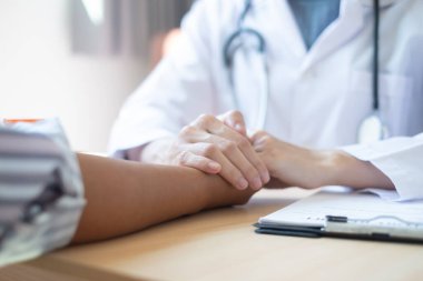 Kadın doktor, hastanın elini tutmak için dost canlısı bir el kullanır. Güvenini kazanmak ve sağlık hizmetlerine önem verdiğini göstermek için. Tıbbi kavramlar ve sağlık.