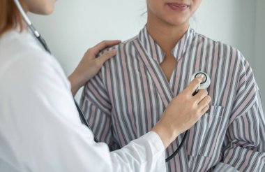 Kadın doktor kan basıncını ölçtü, hasta kalp atışlarını inceledi ve sağlık hizmetleri hakkında yakından konuşmak için oturdu. sağlık hizmeti kavramı.