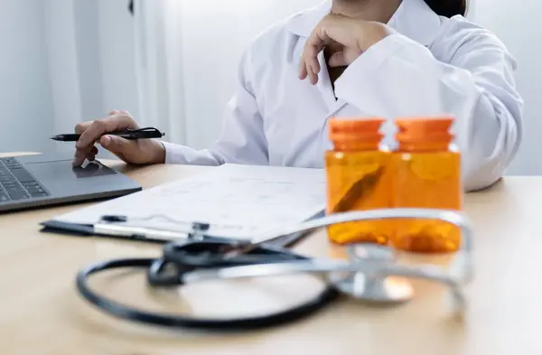 stock image The female doctor sat and checked the patient's history and used a laptop to record patient information at the hospital. Medical concepts and interests.