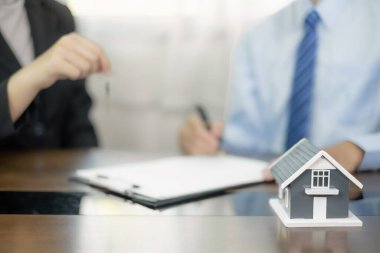 Emlak komisyoncusu, bir ev kiralama ve ev sigortası resmi olarak tamamlandıktan sonra evin anahtarını yeni sahibine teslim eder..