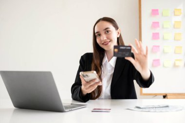 Asyalı kız internet üzerinden alışveriş yapıyor ve akıllı telefon kullanıyor. Cep telefonu numaralarını internet mağazasından satın almak ve ödemek için cep telefonu uygulamasına girin..